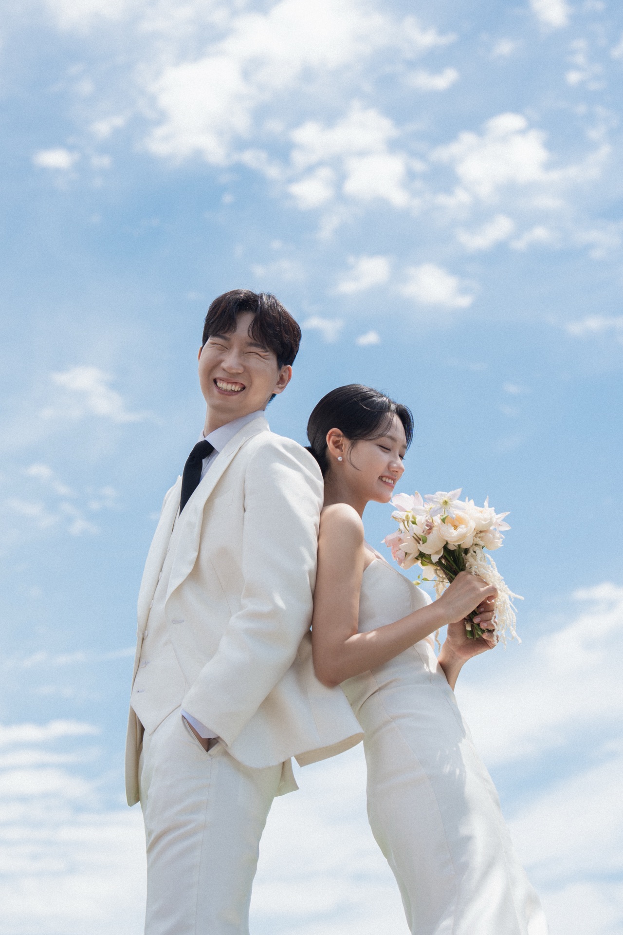 푸른 여름 하늘 아래 함께 선 신랑 신부